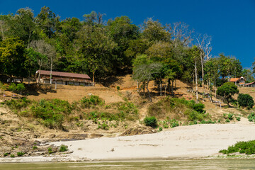 Fototapeta na wymiar A small house on a hill next to a river in Thailand.