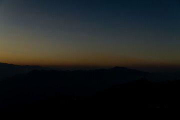 The sun sets among the mountains.