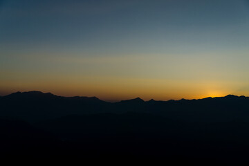 The sun sets among the mountains.