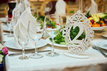 The setting of the festive table. Food and dishes. Festive glasses for drinks.