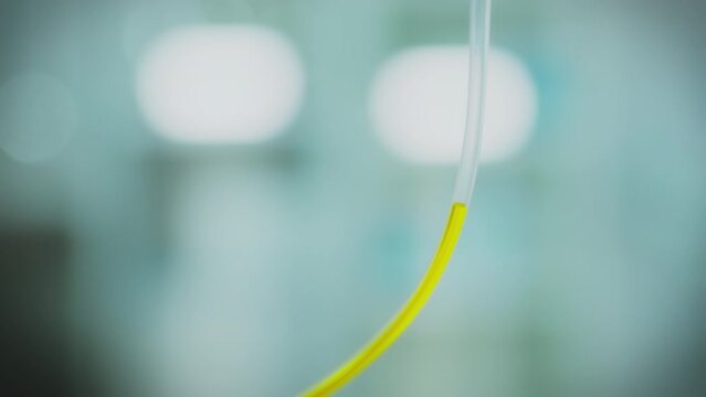The drug is infused through a clear tube where a bright yellow liquid flows to form a stream. The iv drip procedure allows you to effectively introduce medications into the body