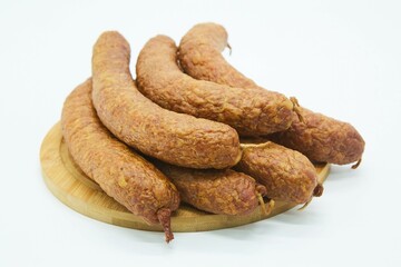 Meat dish sausage on a wooden board. The product is ready to use. White background.