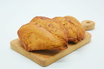 Meat dish smoked chicken breasts on a wooden board. The product is ready to use. White background.