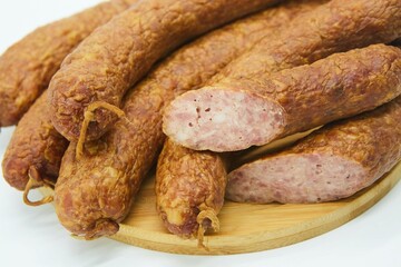 Meat dish sausage on a wooden board. The product is ready to use. White background.