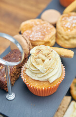 A beautiful gourmet selection of english afternoon tea cakes and scones served with organic cupcakes, tea and coffee, strawberry jam and clotted cream. traditional british food.