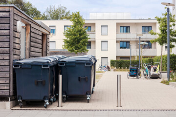 Garbage Cans or Trash Bin Row Front of Modern Apartment Building. City Containers with Waste for...