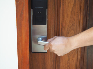 Digital door. Door access control - man hand holding white mockup key card to lock and unlock door. 