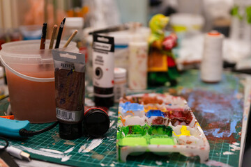 The Artist's Colorful Workspace: A Table Laden with Paints, Creating a Working Atmosphere