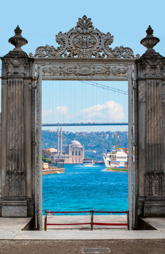 The eastern gate of the Dolmabahce Palace on the shores of the Bosphorus with Ortakoy mosque