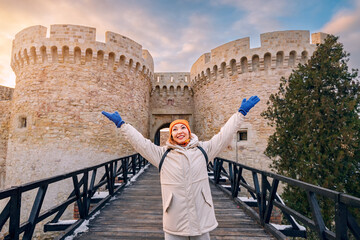 Happy tourist girl at the Zindan gate entrance to Kalemegdan fortress. Travel attractions and...