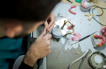 Dental technician grinds a tooth to prepare dental prosthesis