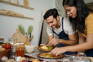 Man and woman making a pizza.