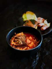 Borsch soup plate with garlic buns, food frame, half plate close up isolated on black background. Ukrainian national food restaurant.