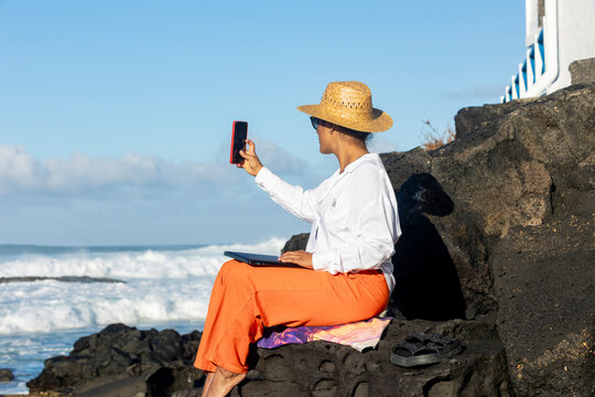 Woman remote work from a scenic Fuerteventura fishing village