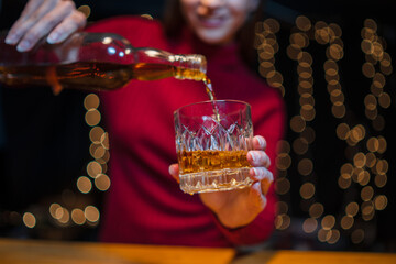 Barwoman pouring whiskey whiskey glass..