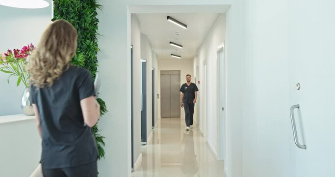 Healthcare Professionals Walking in Clinic Corridor with Greenery