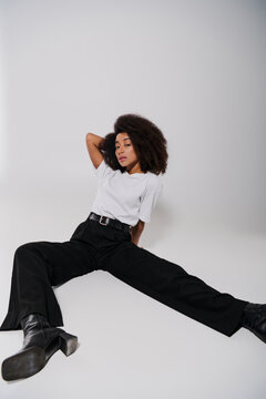 beautiful african american female model sitting on floor and looking at camera, fashion concept