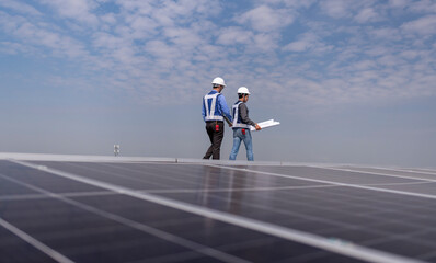 Engineers walking on factory roof inspect survey and check solar cell panel .solar cell is smart...