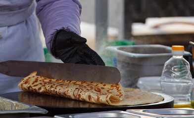 The midsection body of a chef preparing crepes, French pancakes at farmers market stall in Prague...