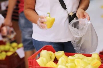 Fotobehang Unrecognisable adult woman chooses yellow pepers buys vegetables in a grocery store or supermarket, holds bio carrier bag. Concept of shopping groceries and healthy vegetarian lifestyle. © Andriy Medvediuk