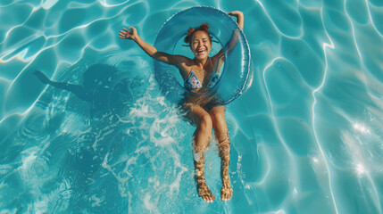 Smiling exited young woman in swimming pool floating on swimming ring