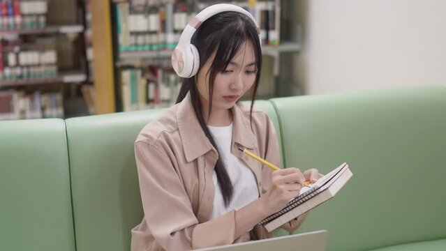 young asian student woman doing lesson exam at college library