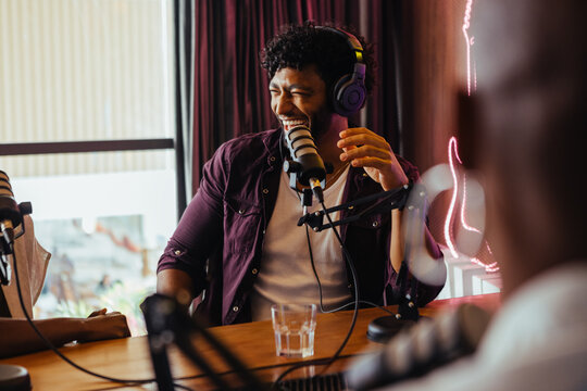 Happy radio host engaged in lively discussion with guest during radio show