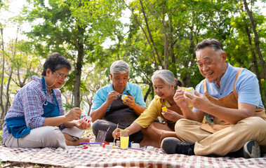 A group of Asian senior people enjoy painting cactus pots and recreational activity or therapy outdoors together  at an elderly healthcare center, Lifestyle concepts about seniority