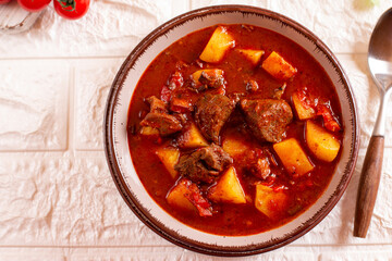 Beef stew served with cooked potatoes and vegetables with paprika and spices. Typical Czech food. Hungarian cuisine. Top view, copy space