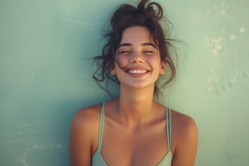 A radiant young woman with a charming smile, wearing casual summer attire, against a soft blue background.