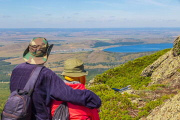 happy mature married couple traveling through the Ural mountains on a summer day