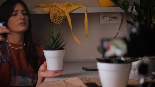 Young woman creating a vlog about caring for houseplants. Content includes gardening tips, floral arrangements, and plant care techniques. Ideal for plant enthusiasts and gardening enthusiasts.