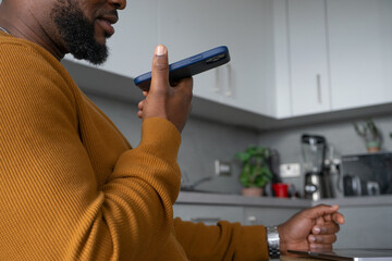 Mid section of man using smart phone in kitchen - obrazy, fototapety, plakaty