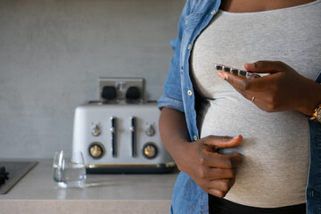 Mid section of pregnant woman holding capsules - Powered by Adobe