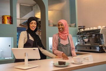 Smiling young women working in cafe