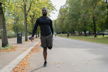 Portrait of athletic man stretching leg in park