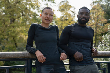 Portrait of athletic man and woman relaxing in park