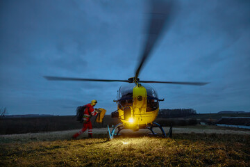 Paramedic in blurred motion running with equipment to helicopter of emergency medical service at...