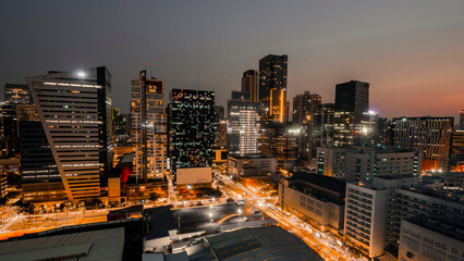 Naklejka premium Captivating twilight scenery of the BGC business district skyline in Metro Manila with illuminated buildings.
