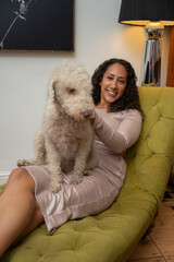 Woman sitting with bedlington terrier on her lap