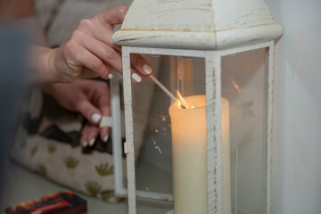 Woman igniting candle in lantern
