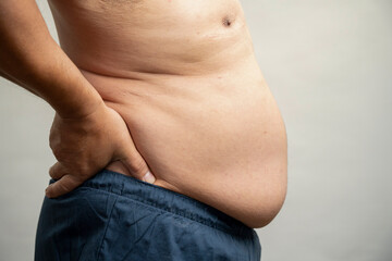 Naklejka premium Profile view of man with pot belly against gray background