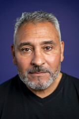 Obraz premium Portrait of serious man against purple background