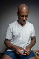 Focused man cutting nails against gray background