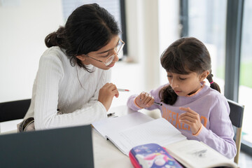 Girl helping little sister doing homework