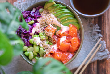 Top view of poke bowl with salmon on the wooden table