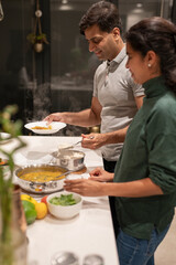 Husband and wife putting food on plates