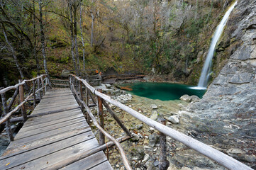 View of the Balta di Stringa waterfall with wooden bridge near the village of Iliochori at the area of Zagori in Epirus, Greece