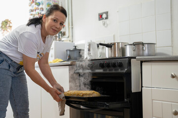 Mature woman baking food in kitchen - obrazy, fototapety, plakaty