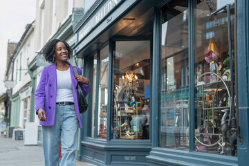 Smiling woman walking and looking at store window